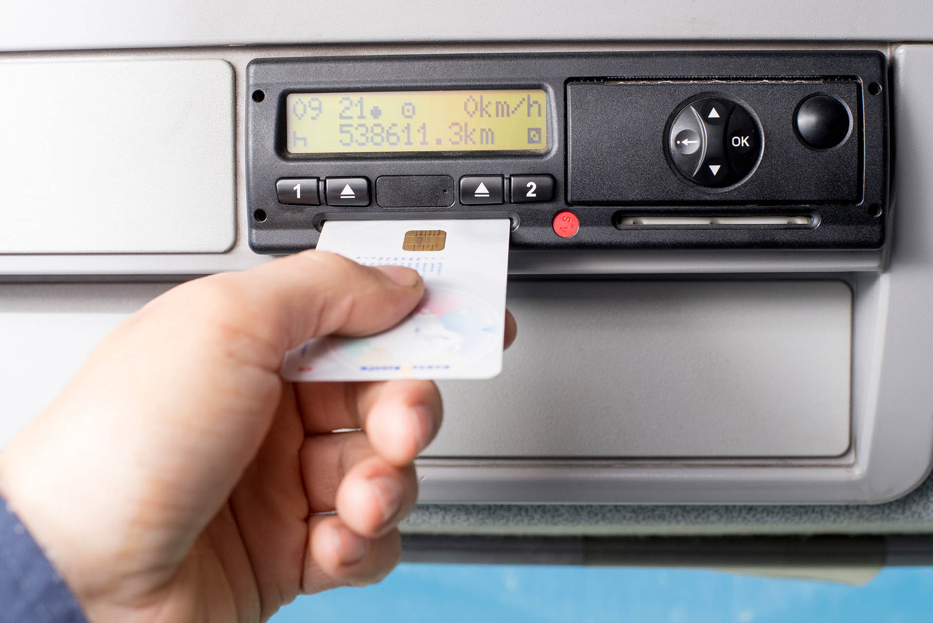 digital,tachograph,and,drivers,hand,inserting,drivers,card,in,it.